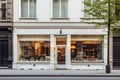 White pastry shop cafe facade with large window showcasing interior, city setting.