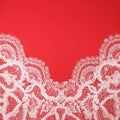 White pattern lace on red background. Top view on tender thin fabric, copy space for romantic text