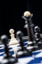 White pawn against black pieces Royalty Free Stock Photo