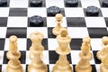 White pawn and black checkers disc moves closeup Royalty Free Stock Photo