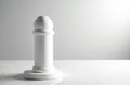 A white pawn chess piece standing on a flat surface with a plain background Royalty Free Stock Photo