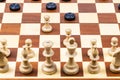 White pawns attack black checkers on wood board Royalty Free Stock Photo