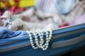 White pearl beads look out of suitcase Royalty Free Stock Photo