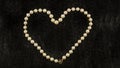 White pearl heart on black fur background Royalty Free Stock Photo