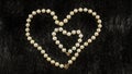 White pearl heart on black fur background Royalty Free Stock Photo