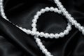 White pearl necklace on a black silk Royalty Free Stock Photo