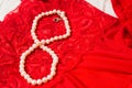 White pearls in 8 lying on red lace. Soft focus Royalty Free Stock Photo
