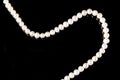 White pearls necklace on black background. Royalty Free Stock Photo