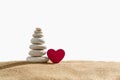 White pebble tower with a red heart on the sand on a white isolated background Royalty Free Stock Photo