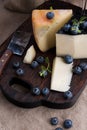 White pecorino cheese and blueberries. Traditional Italian hard cheese and a glass of red wine. Wooden background and dark style Royalty Free Stock Photo