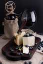 White pecorino cheese and blueberries. Traditional Italian hard cheese and a glass of red wine. Wooden background and dark style Royalty Free Stock Photo