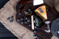 White pecorino cheese and blueberries. Traditional Italian hard cheese and a glass of red wine. Wooden background and dark style Royalty Free Stock Photo