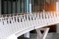 White pedestrian bridge with wooden handrails in the modern area of the city Royalty Free Stock Photo