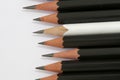 White pencil in a group of black pencils Royalty Free Stock Photo