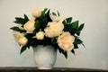 A white peony flower bouquet in a color vase on a white background