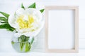 White peony flower in vase on white wooden background with mockup or copy space
