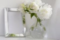 White peony in glass vase on white background. Metal frame. Royalty Free Stock Photo