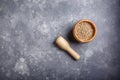 White peppercorns in a mortar for spices. Wooden mortar and pestle full with white pepper on gray background. Top view. Copy space