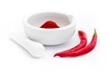 White pestle in front of the white mortar with grinded paprika spice isolated on the white background