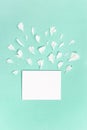 White petals of peony flowers and blank sheet for text on green background. Mock up invitations or holiday greetings Royalty Free Stock Photo