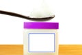 White petroleum jelly in spoon with jar in white background