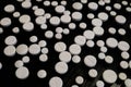 White pharmaceutical round pills on a dark table