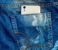 White phone in the back pocket of blue jeans Royalty Free Stock Photo