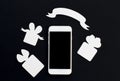White phone with gift boxes and blank ribbon banner on black background.