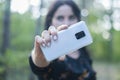 White phone in the hand of a young woman.