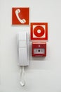 White phone , red fire button on the wall