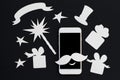 White phone in paper cut collage with magic wand and presents. Royalty Free Stock Photo