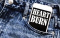 White phone with text Heart Burn lies in jeans pocket Royalty Free Stock Photo