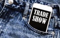 White phone with text Trade Show lies in jeans pocket