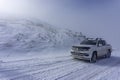 The white pick up truck is riding on snow at a foggy day in Antalya, Turkey