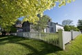 White picket fence in the front yard of a wooden historic cabin