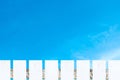 White picket fence and soft white clouds blue sky. Royalty Free Stock Photo