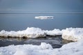 White pieces of ice floating in the sea, winter landscape from the sea, calm water, sky reflections in the sea