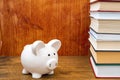 White piggy bank on the bookshelf with stacked books Royalty Free Stock Photo