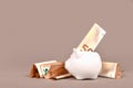 White piggy bank with 50 Euro bills on beige background with copy space. Concept for saving money Royalty Free Stock Photo