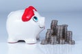 A white piggy bank in front of stacks of coins Royalty Free Stock Photo