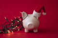 White piggy bank money box covered in festive fairy lights, Christmas saving background Royalty Free Stock Photo