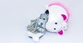 White piggy bank with pink ears and tutu broken with US currency falling out Royalty Free Stock Photo