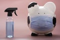 white piggy bank, wearing a surgical doctor mask and hand sanitizer bottle alcohol Royalty Free Stock Photo