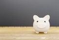 White piggy bank on wooden background with money saving concept Royalty Free Stock Photo