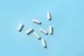 White pill capsules on a blue background. Isolate. Close-up. Medical concept. Royalty Free Stock Photo
