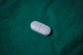 white pill isolated on green background, top view Royalty Free Stock Photo