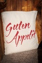 on a white pillow on a bench are the words Guten Appetit Royalty Free Stock Photo