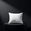 A white pillow on a black pedestal with a spotlight shining down from the upper left corner Royalty Free Stock Photo