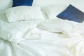 White pillow and dark blue on bed and with wrinkle messy blanket in bedroom, from sleeping in a long night, an unmade bed in hotel Royalty Free Stock Photo