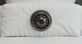 A white pillow with a metal combination lock embedded in its center. The lock is circula Royalty Free Stock Photo